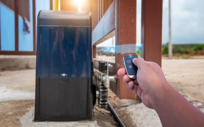 Person,Holding,Remote,Control,To,Open,Automatic,Gate,At,House Person holding remote control to open automatic gate at house is home security system for control transportation entry.